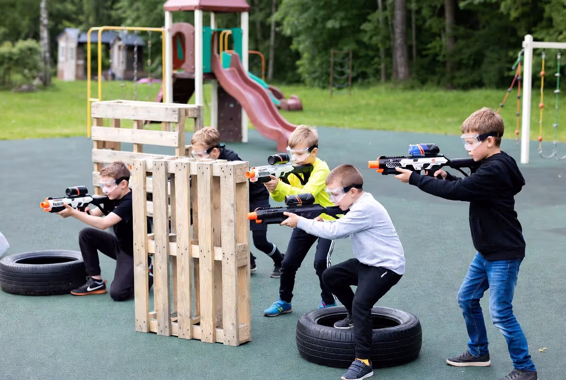 Kids playing gellyball using cover and teamwork during match