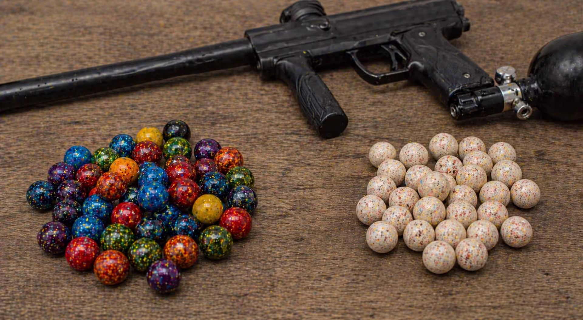 comparison of standard paintballs and pepper balls on table with marker